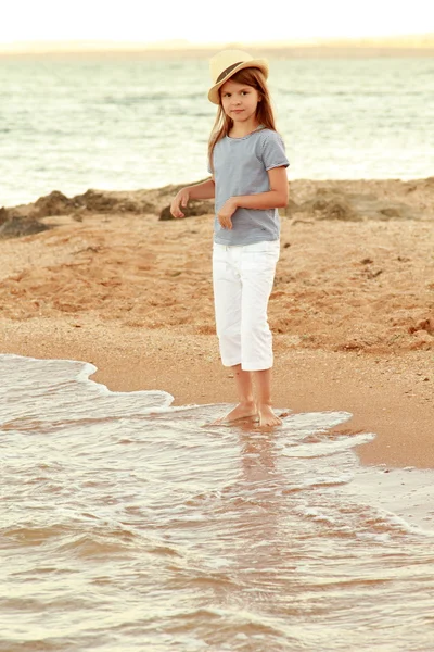 Çekici neşeli küçük kız gülümseyerek ve yaz deniz için poz yaz şapka içinde. — Stok fotoğraf