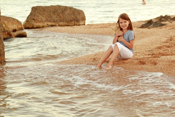 Bella ragazza caucasica con i capelli lunghi e un dolce sorriso appoggiato sull'oceano . — Foto Stock