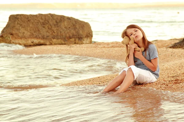 Beautiful young caucasian girl with long hair and a sweet smile resting on the ocean. — Stock Photo, Image