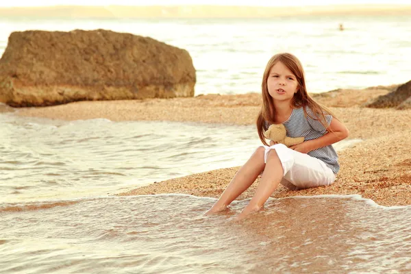 Emotionele vreugdevolle jong meisje wandelen op het strand bij zonsondergang. — Stockfoto