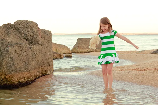 Emotional joyful young girl walking on the beach at sunset — Stock Photo, Image