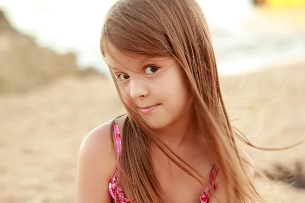Retrato de una linda niña sonriente en traje de baño sosteniendo una hermosa concha — Foto de Stock