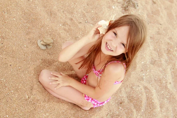 Portret van een schattig klein meisje met een schelp — Stockfoto