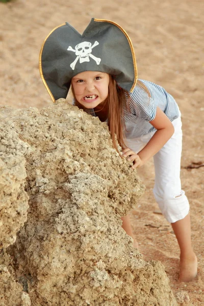 Beautiful cheerful little girl in a pirate costume is studying a treasure map — Stock Photo, Image