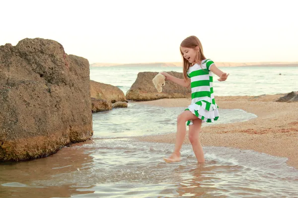 Emoční radostné mladá dívka procházky na pláži při západu slunce — Stock fotografie