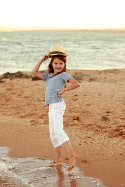 Encantadora niña alegre en un sombrero de verano sonriendo y posando para el mar de verano — Foto de Stock