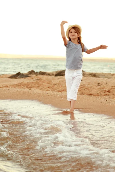 Jovem menina alegre emocional andando na praia ao pôr do sol — Fotografia de Stock