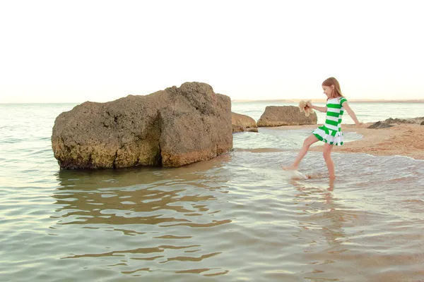 Emotional joyful young girl walking on the beach at sunset — Stock Photo, Image