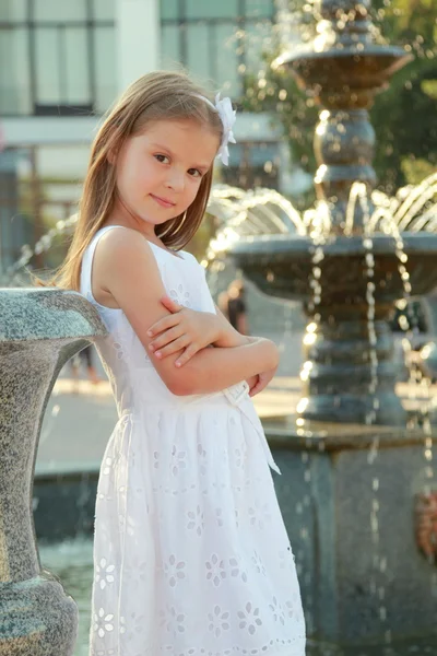 Kaukasische mooi glimlachend kind meisje in de buurt van fontein in sammer — Stockfoto