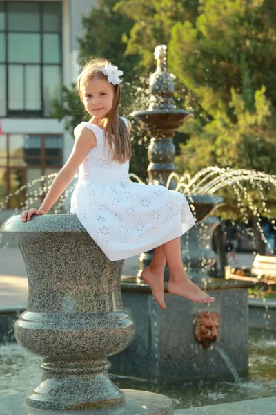 Caucasian lovely smiling child girl near fountain in sammer — Stock Photo, Image