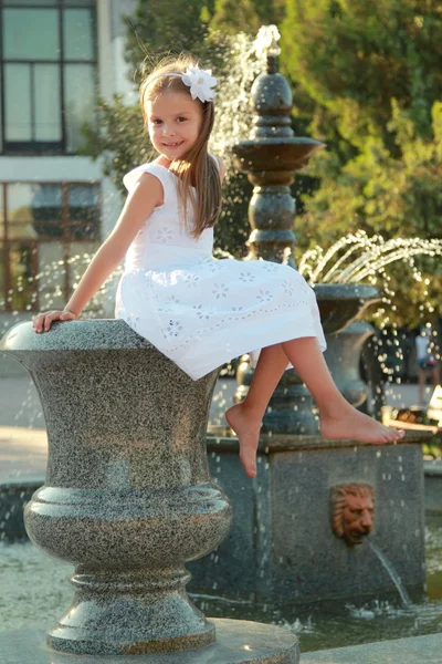 Caucasian lovely smiling child girl near fountain in sammer — Stock Photo, Image