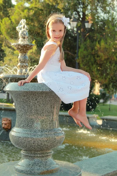 Caucasian lovely smiling child girl near fountain in sammer — Stock Photo, Image