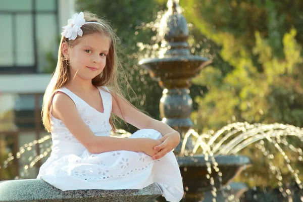 Caucasian lovely smiling child girl near fountain in sammer — Stock Photo, Image