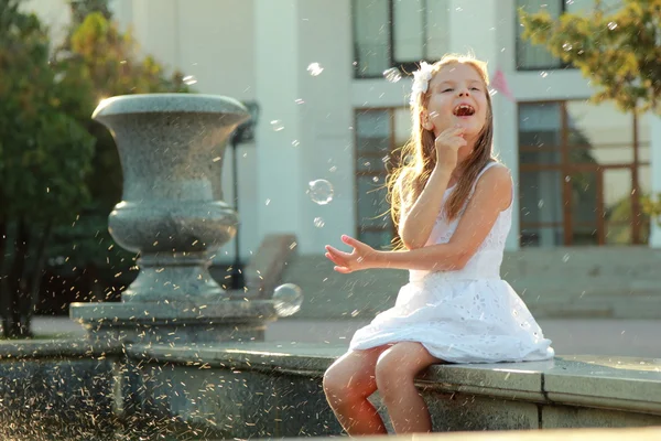Kavkazská krásné usmívající se dítě dívka u fontány v sammer — Stock fotografie