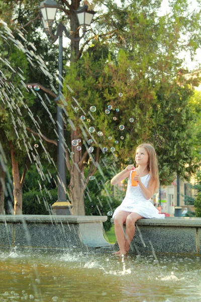 Caucásico precioso sonriente niña cerca de la fuente en sammer —  Fotos de Stock