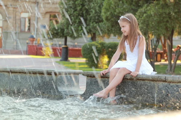Кавказская милая улыбающаяся девочка у фонтана в Саммере — стоковое фото
