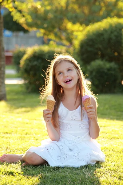 Lächelndes Kind isst Eis im Sommerpark. — Stockfoto