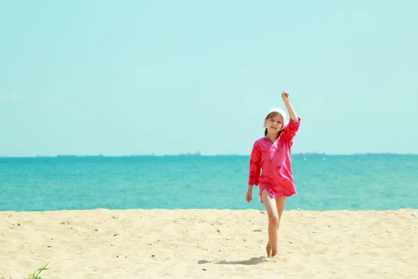 Söt liten tjej har en rolig på sandstranden bakgrund — Stockfoto