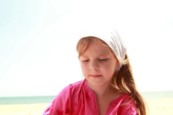 Sevimli küçük kız var eğlenceli bir kumsala arka plan üzerinde — Stok fotoğraf