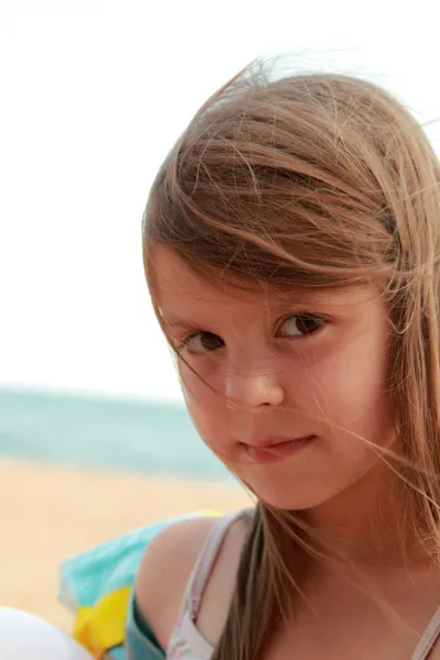 Caucasian lovely little girl smiling on a background of blue sea — Stock Photo, Image