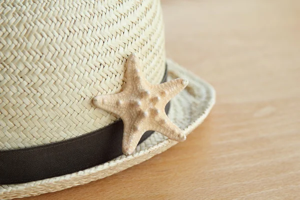 Starfish and summer hat on the old wooden background — Stock Photo, Image