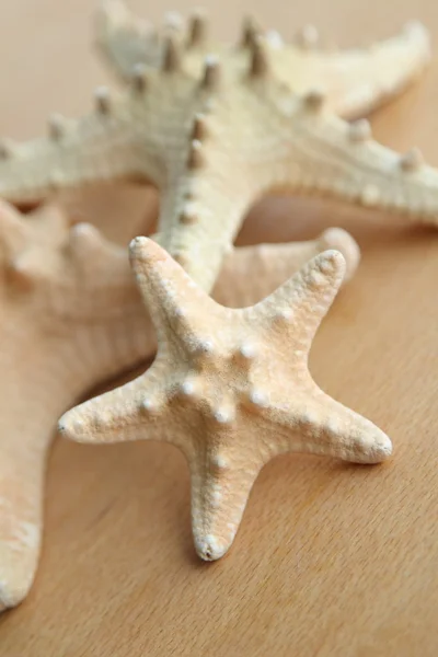 Beautiful sea stars on wooden background — Stock Photo, Image