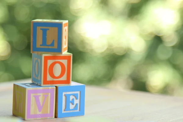 Palavra amor de cubos infantis coloridos em fundo turvo — Fotografia de Stock