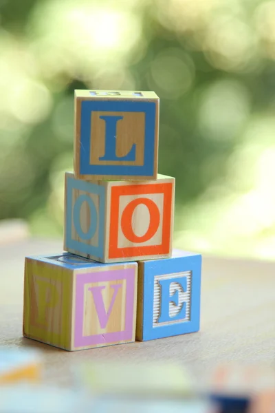 Palabra de amor de los cubos de los niños de color sobre fondo borroso —  Fotos de Stock