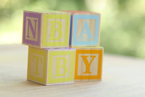 Word baby bekleed met kinderen van houten blokken voor basisonderwijs alfabet — Stockfoto