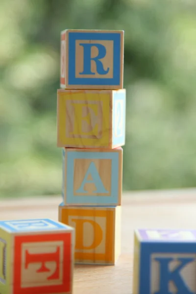 Palavra "Leia" de cubos coloridos para crianças pré-escolares aprendendo a ler no fundo embaçado — Fotografia de Stock