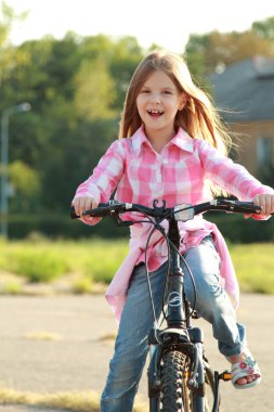 neşeli küçük kız bir bisiklet sürme