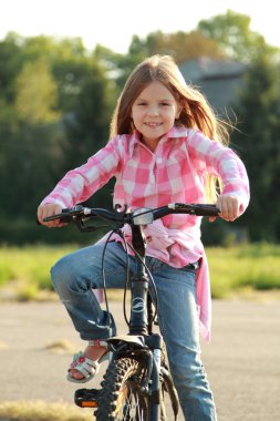 neşeli küçük kız bir bisiklet sürme