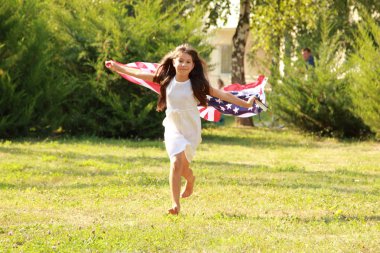 büyük bir Amerikan bayrağı tutan kız