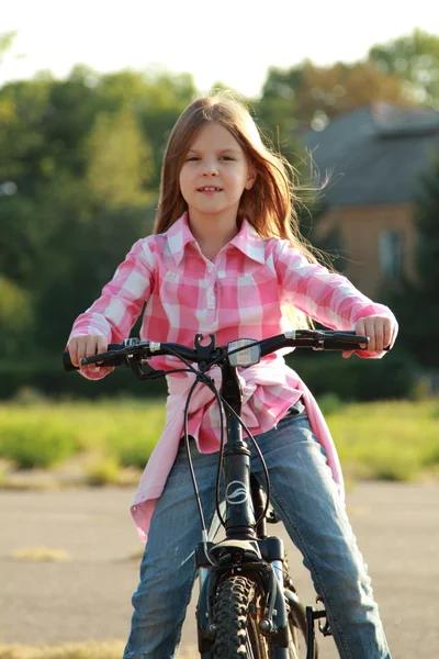 Niña alegre montando una bicicleta — Foto de Stock