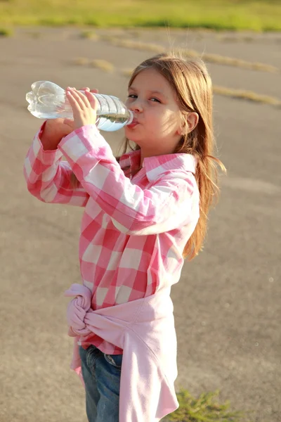 Cute little girl drinks water — Stock Photo, Image