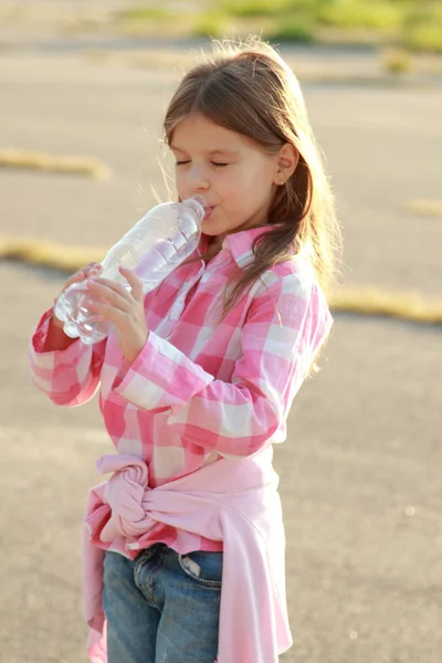 Cute little girl drinks water — Stock Photo, Image