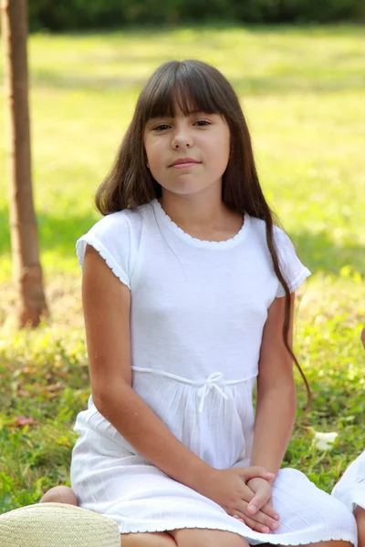 Menina sentada na grama verde — Fotografia de Stock