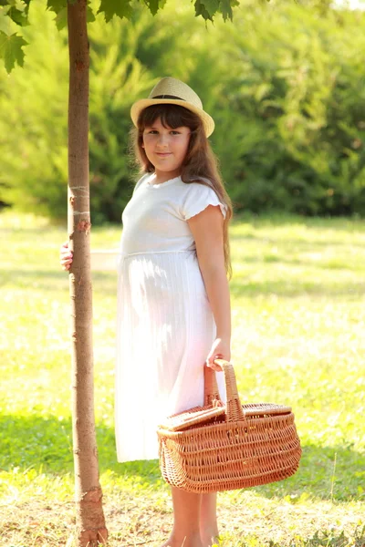 Junges Mädchen mit einem Korb für ein Picknick — Stockfoto