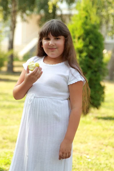 Menina come uma maçã em um dia de verão — Fotografia de Stock