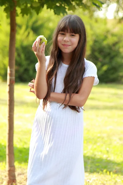 女孩一边吃着苹果，在炎热的夏天 — 图库照片