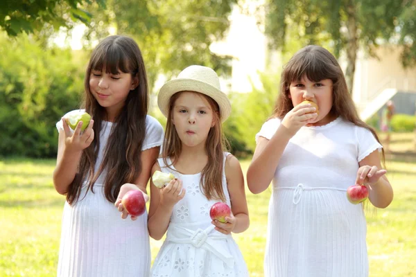 Flickor äta äpplen i naturen — Stockfoto