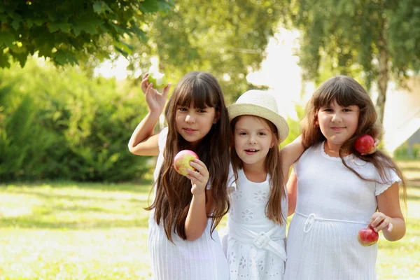 Meninas comendo maçãs na natureza — Fotografia de Stock