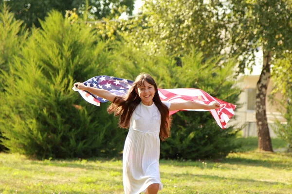 Büyük bir Amerikan bayrağı tutan kız — Stok fotoğraf