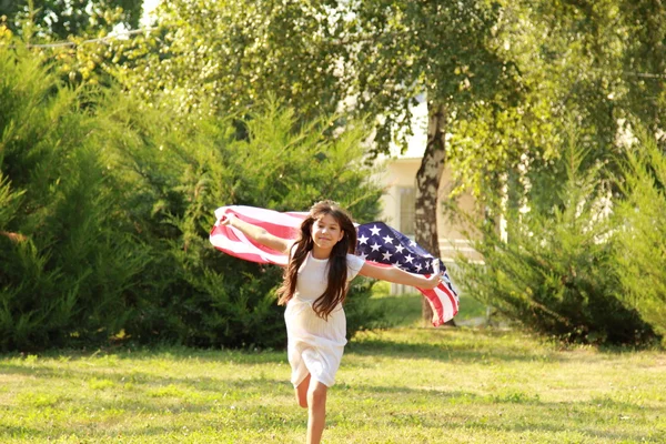 büyük bir Amerikan bayrağı tutan kız