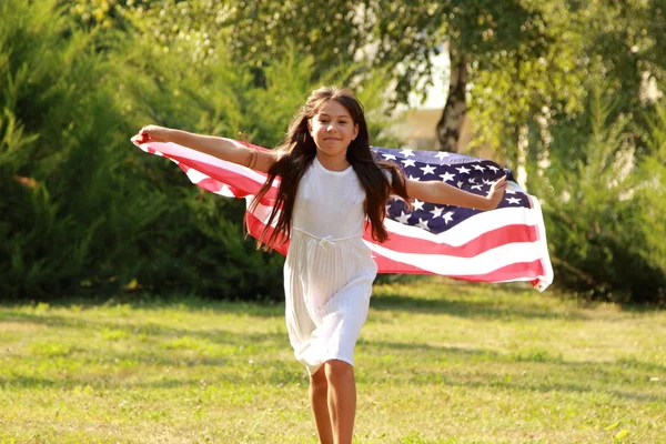 Дівчинка тримає великий американський прапор — стокове фото
