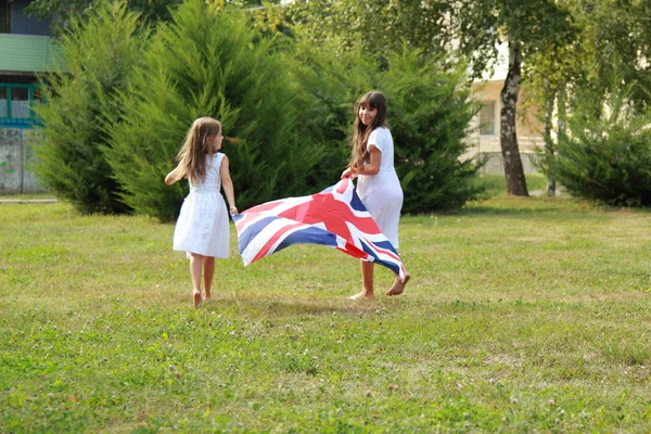 Little girls carry the flag of the UK — Stock Photo, Image