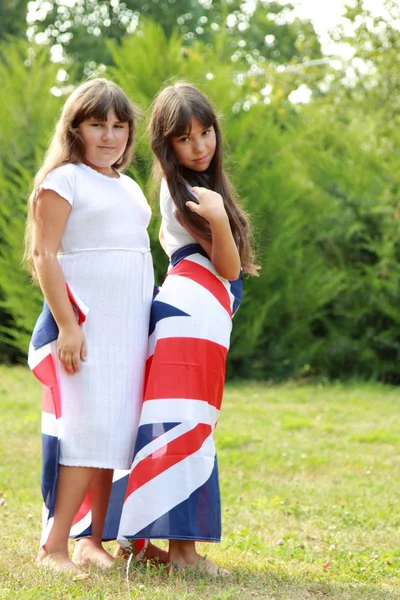 Dwa Uśmiechający Się Dziewczynki Białych Sukniach Prowadzić Flaga Wielkiej Brytanii — Zdjęcie stockowe