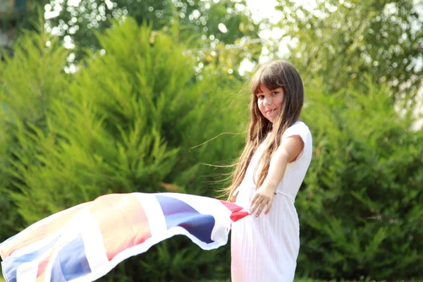 Söt flicka håller en stor Storbritannien flagga — Stockfoto