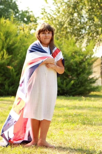 Mignonne fille tenant un grand drapeau britannique — Photo