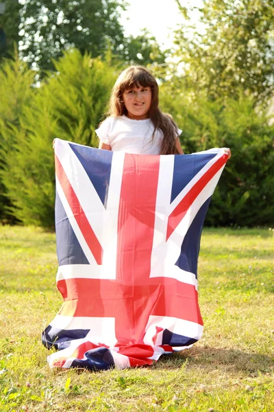 Chica en un parque con bandera de Gran Bretaña — Foto de Stock